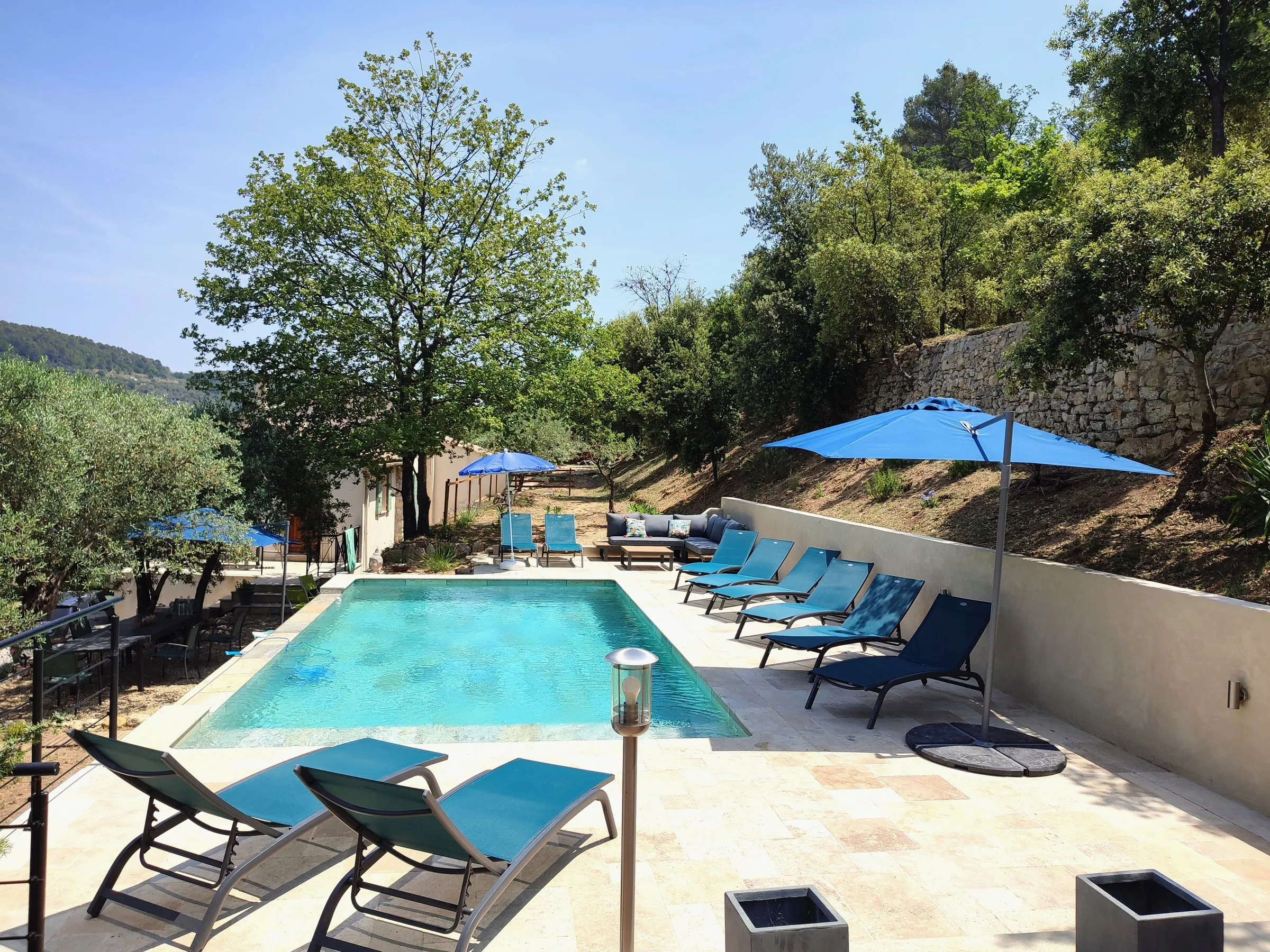 Piscine et parasols bleus en fin de journée